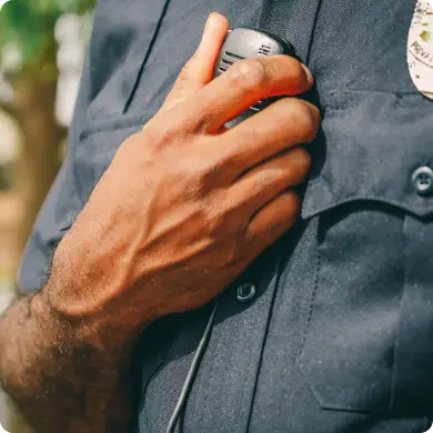 Primer plano de la mano de un guardia sosteniendo un radio de comunicación